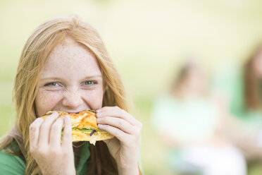 Porträt eines Mädchens mit roten Haaren, das ein Sandwich isst - ZEF004382