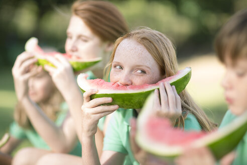 Porträt eines Mädchens, das eine Scheibe Wassermelone isst und einen Jungen beobachtet - ZEF004363