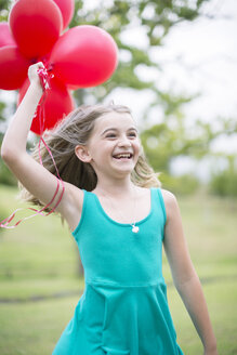 Porträt eines lächelnden Mädchens mit roten Luftballons - ZEF004392