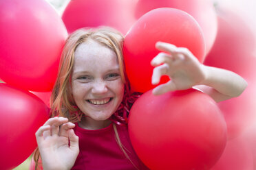 Portrait of smiling girl with red balloons - ZEF004394