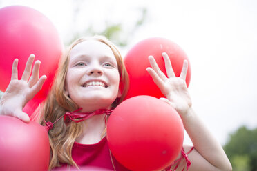 Portrait of smiling girl with red balloons - ZEF004395