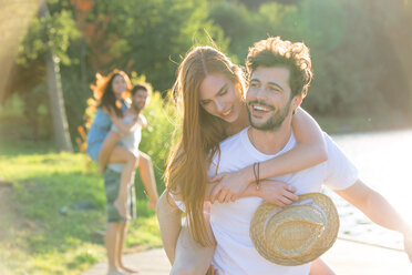 Happy young man carrying girlfriend piggyback - WESTF020715