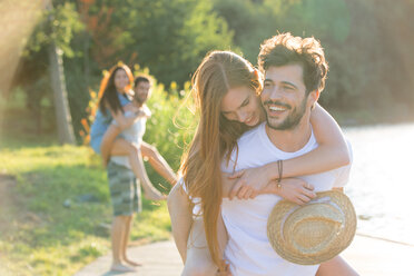 Happy young man carrying girlfriend piggyback - WESTF020716