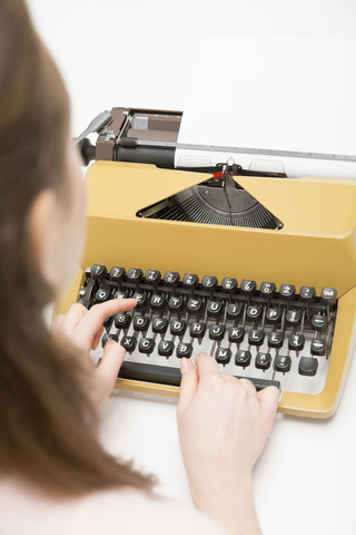 Nahaufnahme einer jungen Frau bei der Arbeit mit einer Schreibmaschine, lizenzfreies Stockfoto