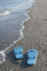 Italien, Adriatisches Meer, blaue Flip-Flops an der Strandpromenade - CRF002632