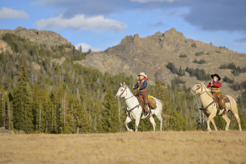 USA, Wyoming, zwei junge Cowboys reiten - RUEF001373