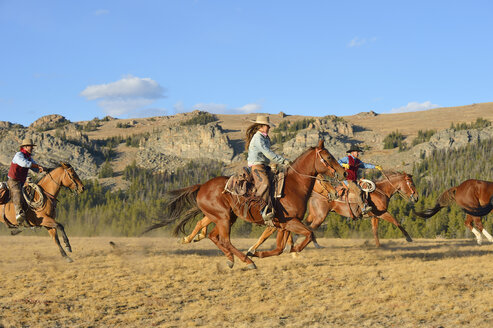 USA, Wyoming, Cowboys und Cowgirl hüten Pferde in der Wildnis - RUEF001380