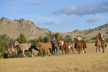 USA, Wyoming, Cowboys und Cowgirls hüten Pferde in der Wildnis - RUEF001382