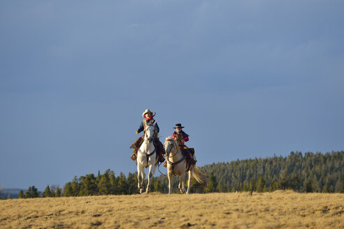 USA, Wyoming, zwei junge Cowboys reiten - RUEF001384