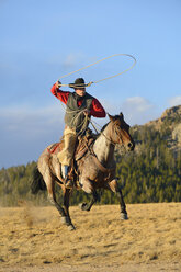 USA, Wyoming, reitender Cowboy, der das Lasso schwingt - RUEF001390