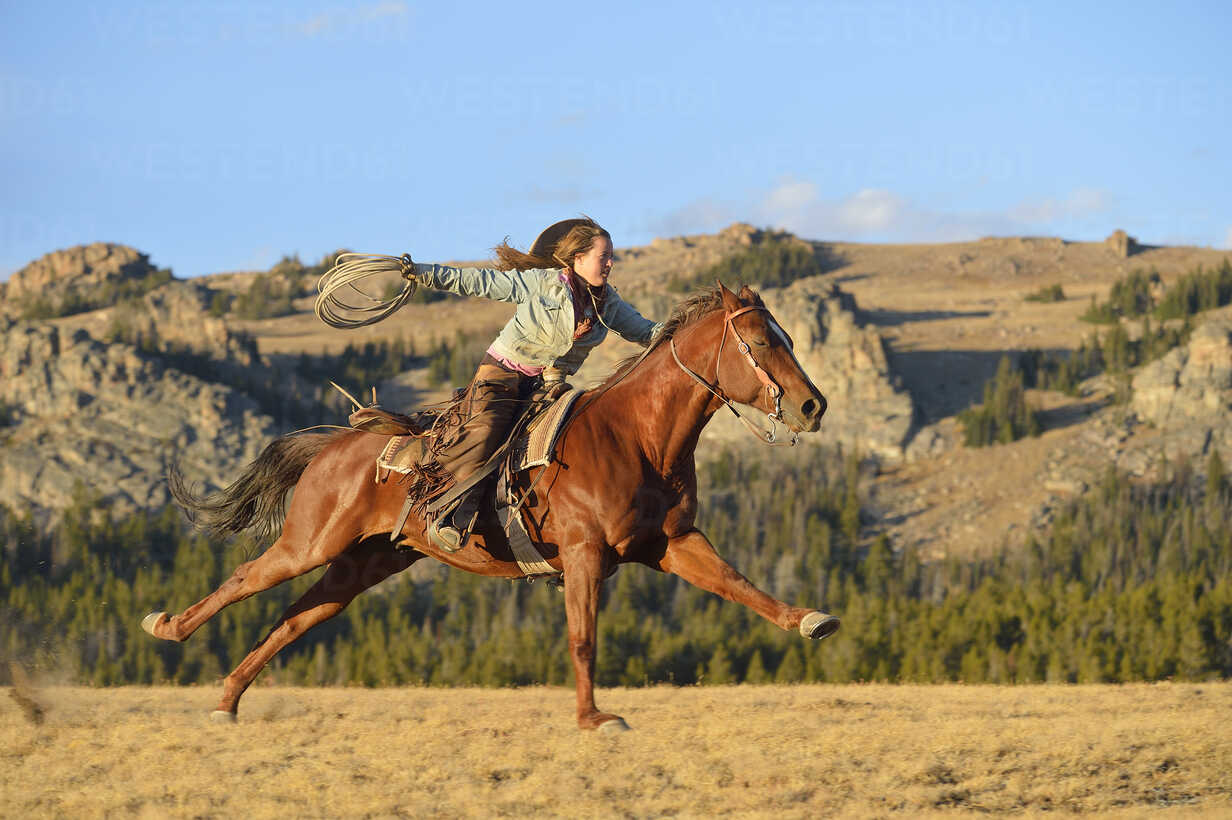 https://us.images.westend61.de/0000500447pw/usa-wyoming-riding-cowgirl-holding-lasso-RUEF001391.jpg