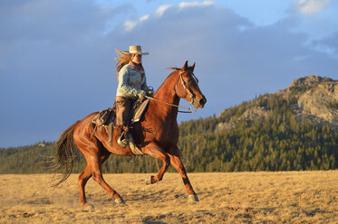 USA, Wyoming, riding cowgirl - RUEF001396