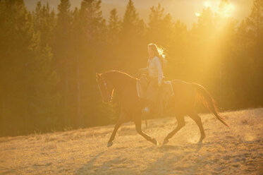 USA, Wyoming, reitendes Cowgirl im Gegenlicht - RUEF001400