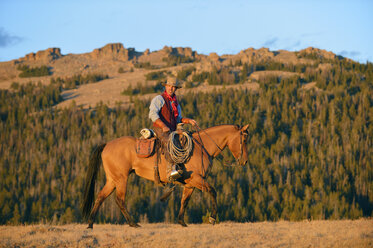 USA, Wyoming, Cowboyreiten im Abendlicht - RUEF001404