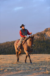 USA, Wyoming, Cowboyreiten im Abendlicht - RUEF001409