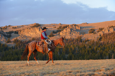 USA, Wyoming, Cowboyreiten im Abendlicht - RUEF001411