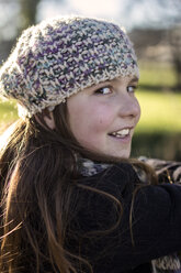 Portrait of girl wearing wool cap viewing over shoulder - MGOF000008