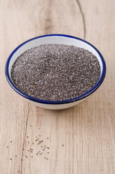 Enamel bowl of chia seeds on wood - ODF001007