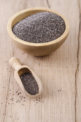 Wooden bowl of chia seeds and wooden shovel on wood - ODF001008