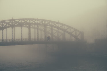 Deutschland, Hamburg, HafenCity, Brücke mit Fußgängern im Nebel - KRPF001258