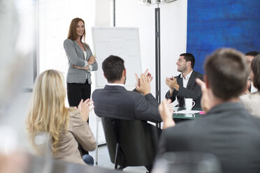 Businesswoman in boardroom leading a meeting with flip chart - ZEF003122