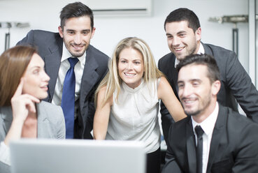 Businesspeople in office looking at laptop - ZEF003129