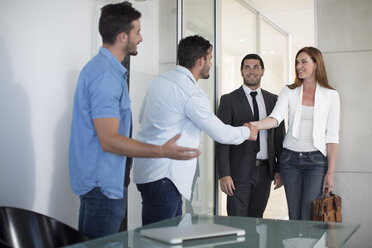 Twin males dressed casually in office meeting with clients - ZEF003135