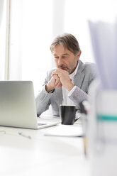 Businessman using laptop at desk - WESTF020491