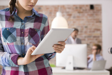Junge Frau benutzt digitales Tablet im Büro - WESTF020517