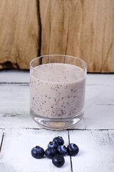 Glas Blaubeer-Smoothie und Blaubeeren auf Holz - ODF001014