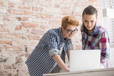 Zwei junge Frauen im Büro arbeiten am Laptop - WESTF020615