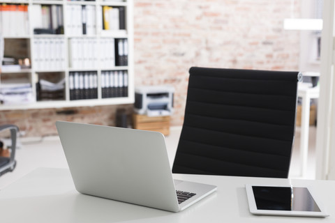 Laptop und digitales Tablet auf dem Schreibtisch im Büro, lizenzfreies Stockfoto