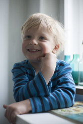 Porträt eines lächelnden kleinen Jungen mit der Hand auf seinem Gesicht - RB002237