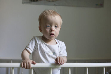 Schläfriger kleiner Junge in seinem Kinderbett - RB002242