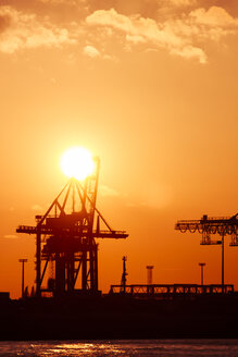 Deutschland, Hamburg, Hafen, Kräne an der Elbe bei Sonnenuntergang - KRPF001274