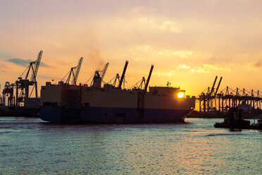 Germany, Hamburg, Port of Hamburg, Container Terminal, container cranes and ship at sunset - KRPF001275