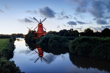 Deutschland, Niedersachsen, Greetsiel, traditionelle Windmühlen im Abendlicht - PAF001210