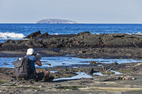 Ecuador, Galapagos-Inseln, Santiago, Mann beim Fotografieren an der Strandpromenade - FOF007281