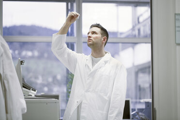 Scientist in microbiological lab looking at sample - SGF001323