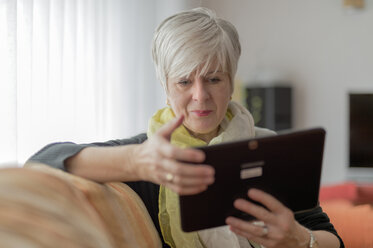 Ältere Frau mit digitalem Tablet auf dem Sofa - FRF000169