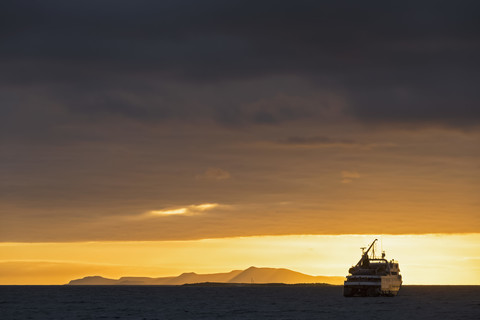 Pazifischer Ozean, Galapagos-Inseln, Rabida, Kreuzfahrtschiff bei Sonnenaufgang, lizenzfreies Stockfoto