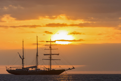 Pazifischer Ozean, Segelschiff vor den Galapagos-Inseln bei Sonnenuntergang, lizenzfreies Stockfoto