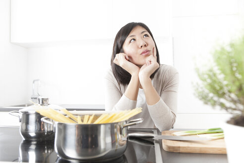 Portrait of pensive young woman cooking spaghetti - FLF000797