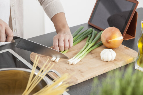 Woman cutting spring onions in the kitchen - FLF000799