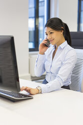 Woman on the phone at desk in office - SHKF000194