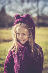 Portrait of smiling litte girl wearing purple hooded jacket - SARF001232