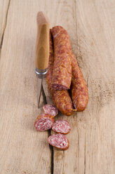 Sliced and whole minced pork sausages and kitchen knife on wood - ODF001038