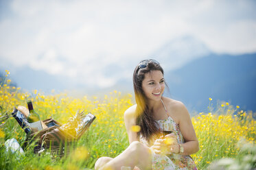 Young woman having picnic on alpine meadow - HHF005031