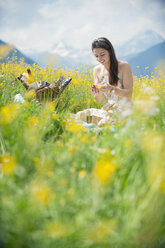 Young woman having picnic on alpine meadow - HHF005032