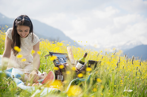 Junge Frau beim Picknick auf einer Bergwiese, lizenzfreies Stockfoto